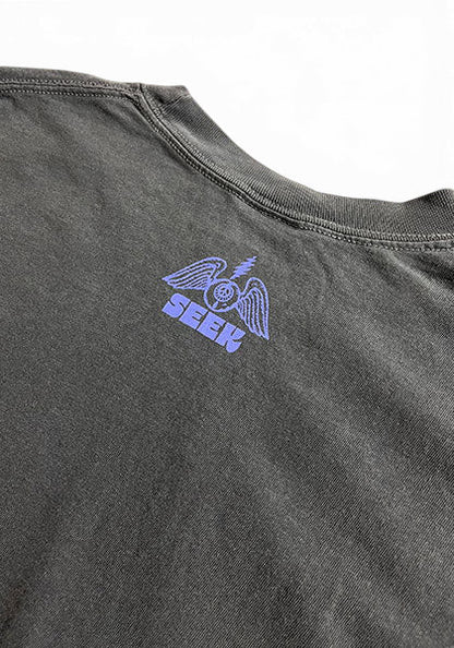 SEEKのDEGARASHIコラボTシャツ。ヴィンテージ風の黒いコットン生地に紫色の翼と目のグラフィックがプリントされたバックネック部分。